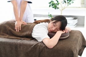 腰をマッサージする整体師